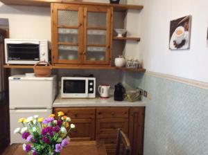 a kitchen with a microwave and a table with flowers at Casa Vacanze Amelia in Fiesole +16 photos