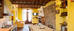cocina y sala de estar con paredes amarillas y mesa. en Casabeppe, en Lucca