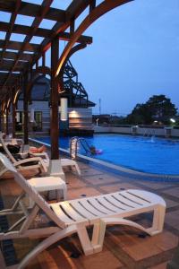 a group of lounge chairs next to a swimming pool at Dhevaraj Hotel in Nan