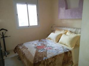 a bedroom with a bed with a quilt on it at Appartement Bader in Marrakesh