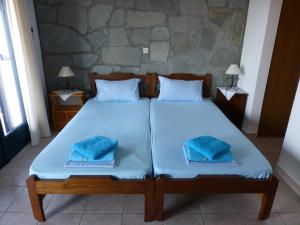 1 dormitorio con 2 camas y toallas azules. en Efterpi, en Mirina