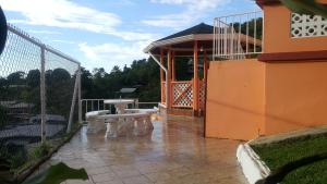 a patio with a table and a gazebo at Golden Apple Cottage in Castara +7 photos