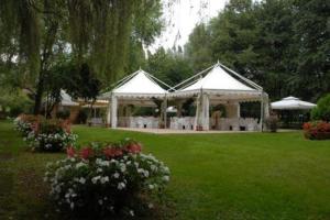 a couple of white tents in a yard with flowers at Hotel L'Ultimo Mulino in Bannia