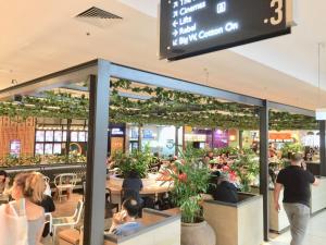 a group of people sitting at tables in a restaurant at 3 Bedrooms Holiday Home Near Sydney Airport in Sydney