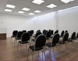 a room with black chairs and a white wall at Rental Suites Pilar in Pilar