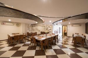 a restaurant with tables and chairs on a checkered floor at Hotel Vaikunth By Adamo in Nāthdwāra