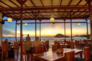 personas sentadas en un restaurante con vistas al océano en Blue Marlin Dive Komodo, en Labuan Bajo