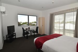 ein Hotelzimmer mit einem Bett, einem Tisch und einem Fenster in der Unterkunft 103 Prince of Bealey Motel in Christchurch