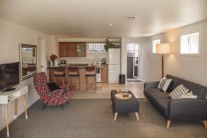 a living room with a couch and a kitchen at Water & City Lights Studio in Tauranga