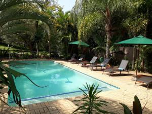 a swimming pool with lounge chairs and umbrellas at The Sandpiper in St Lucia