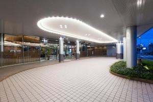 un grand bâtiment avec une passerelle devant lui dans l'établissement Hakata Excel Hotel Tokyu, à Fukuoka