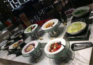 ein Tisch mit vielen Schüsseln Essen drauf in der Unterkunft Air China Boyue Beijing Hotel in Peking