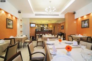 um restaurante com mesas e cadeiras e um lustre em Business Hotel Senator em Ecaterimburgo