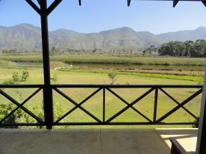 a view of a field and mountains from a window at Springfontein Wine Estate Stanford River Lodge in Stanford
