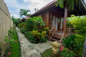 une maison avec un jardin et un chemin menant à celle-ci dans l'établissement Amora Hut's, à Nusa Lembongan