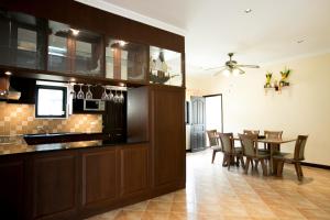 a kitchen and dining room with a table and chairs at Royal Pool Villa Pattaya in Nong Prue