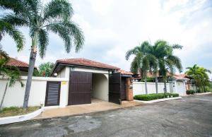 a house with a garage and palm trees at Royal Pool Villa Pattaya in Nong Prue
