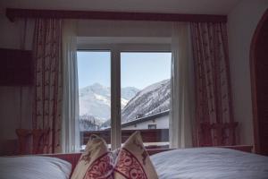 1 dormitorio con ventana y vistas a la montaña en Pension Anna, en Sankt Leonhard im Pitztal