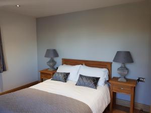 a bedroom with a bed with two lamps on tables at Maple in Burgh le Marsh