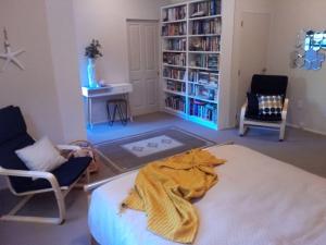 a living room with a bed and two chairs at Dream Escape for 2 in Paraparaumu Beach