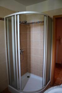 y baño con ducha y puerta de cristal. en Vadszilva Apartman, en Balatonőszöd