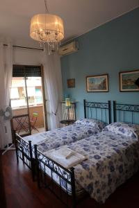 ローマにあるCasa Garbataのベッドルーム1室(ベッド2台、シャンデリア付)