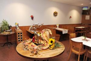 un restaurante con una mesa con flores. en Hotel Restaurant Au Chasseur, en Orbe