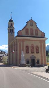 a large building with a clock tower in front of it at Piller Roner Rosa in Sappada