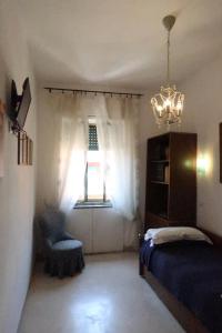 ローマにあるCasa Garbataのベッドルーム1室(ベッド1台、窓、シャンデリア付)
