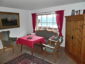 een woonkamer met een tafel en stoelen en een raam bij Haus am See in Ramsau