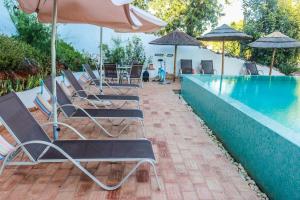 un grupo de sillas y sombrillas junto a una piscina en Casa da Tita, en Salir