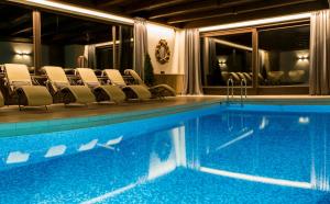 a swimming pool in a hotel with chairs around it at Boutiquehotel Säumler in Zell am Ziller