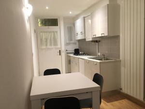 a kitchen with white cabinets and a table and chairs at Fewo Südtirol - Apartments in Bolzano