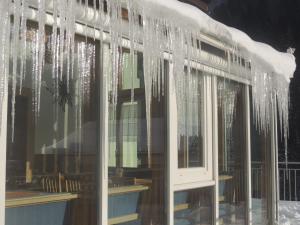 una ventana con carámbanos colgando de ella en Haus Gafrina, en Schruns