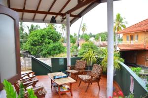 a patio with chairs and a table on a balcony at Lilly Palace Villa Guest House in Negombo