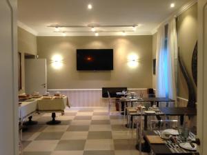 comedor con mesas y TV en la pared en Villa Abbamer, en Grottaferrata