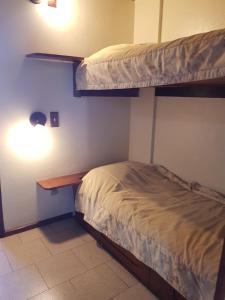 a bedroom with two bunk beds and a desk at Residencial Pousada do Serrano in Gramado