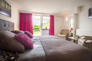 a bedroom with a large bed with purple pillows at Panorama Sousberg B&B en appartementen in Schin op Geul