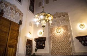 una gran lámpara de araña colgada de una pared en una habitación en Dar Elinor en Fez