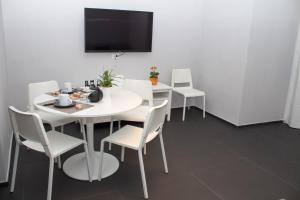 una sala da pranzo con tavolo bianco e sedie bianche di Residenza Spinelli a Napoli