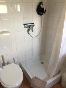 a bathroom with a toilet and a bathtub with a shower curtain at Ferienwohnung Schmidt in Hiddenhausen