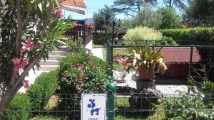 un giardino con piante e un cartello su una recinzione di Apartments Perić a Opatija