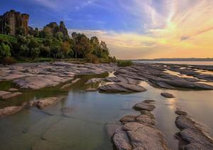 a group of rocks in a body of water at Loft Sirmione in Sirmione