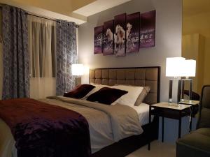 een slaapkamer met een bed met 2 lampen en een bank bij JR Studio Luxe 1824 at Princeton Residences in Manilla