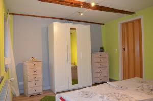 Schlafzimmer mit einem Bett, einer Kommode und einem Spiegel in der Unterkunft Ferienwohnung Pusteblume in Wildemann