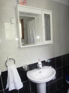 Apartment Ivana في كوتور: حمام مع حوض أبيض ومرآة