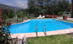 a large blue swimming pool in a yard at La Granja del Pescador in Casas del Castañar