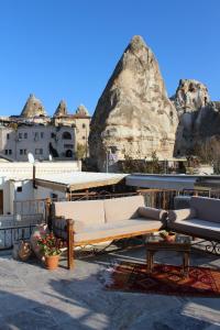 a couch on a roof with a mountain in the background at Hanzade Cappadocia in Göreme