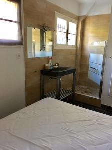 a bedroom with a bed and a sink and a mirror at Villa Olivea in Rayol-Canadel-sur-Mer +15 photos