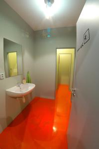 a bathroom with an orange floor and a sink at Penzion UAX in Trojanovice